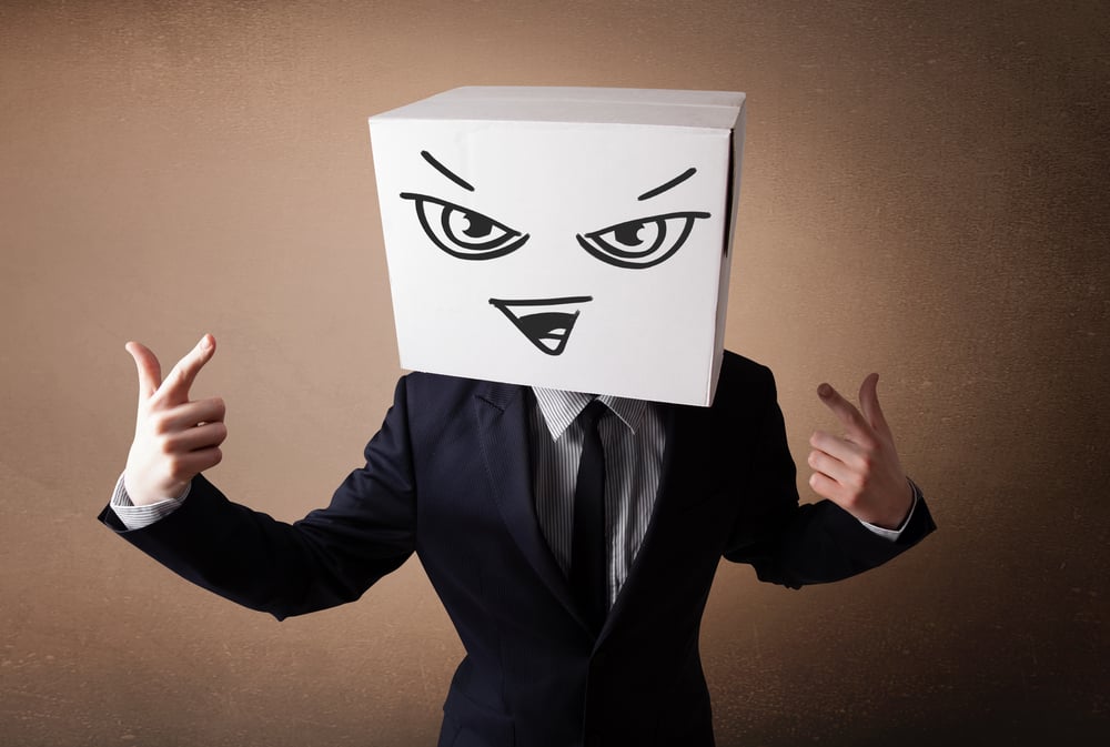 Businessman standing and gesturing with a cardboard box on his head with evil face